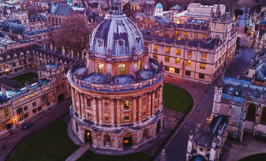 Aerial view of Oxford's Radcliffe Camera and surrounding historic buildings at dusk
