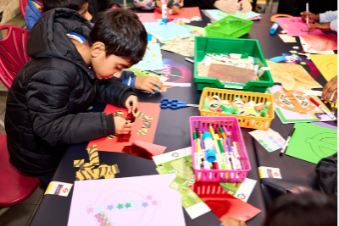 Child making a colourful craft at London Transport Museum