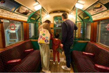 Visitors exploring a historic Tube carriage at London Transport Museum